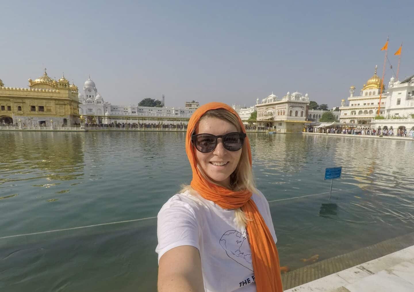 ellie quinn in orange head scarf in the golden temple in Amritsar