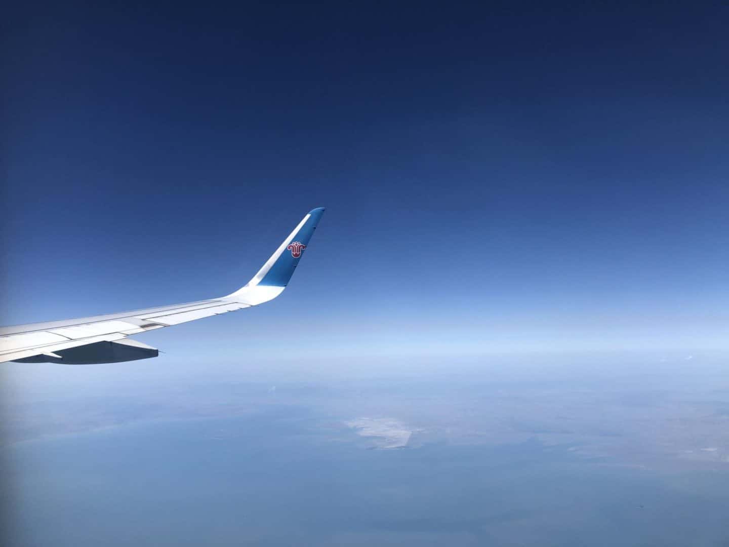 Southern China Airlines flight wing over the ocean