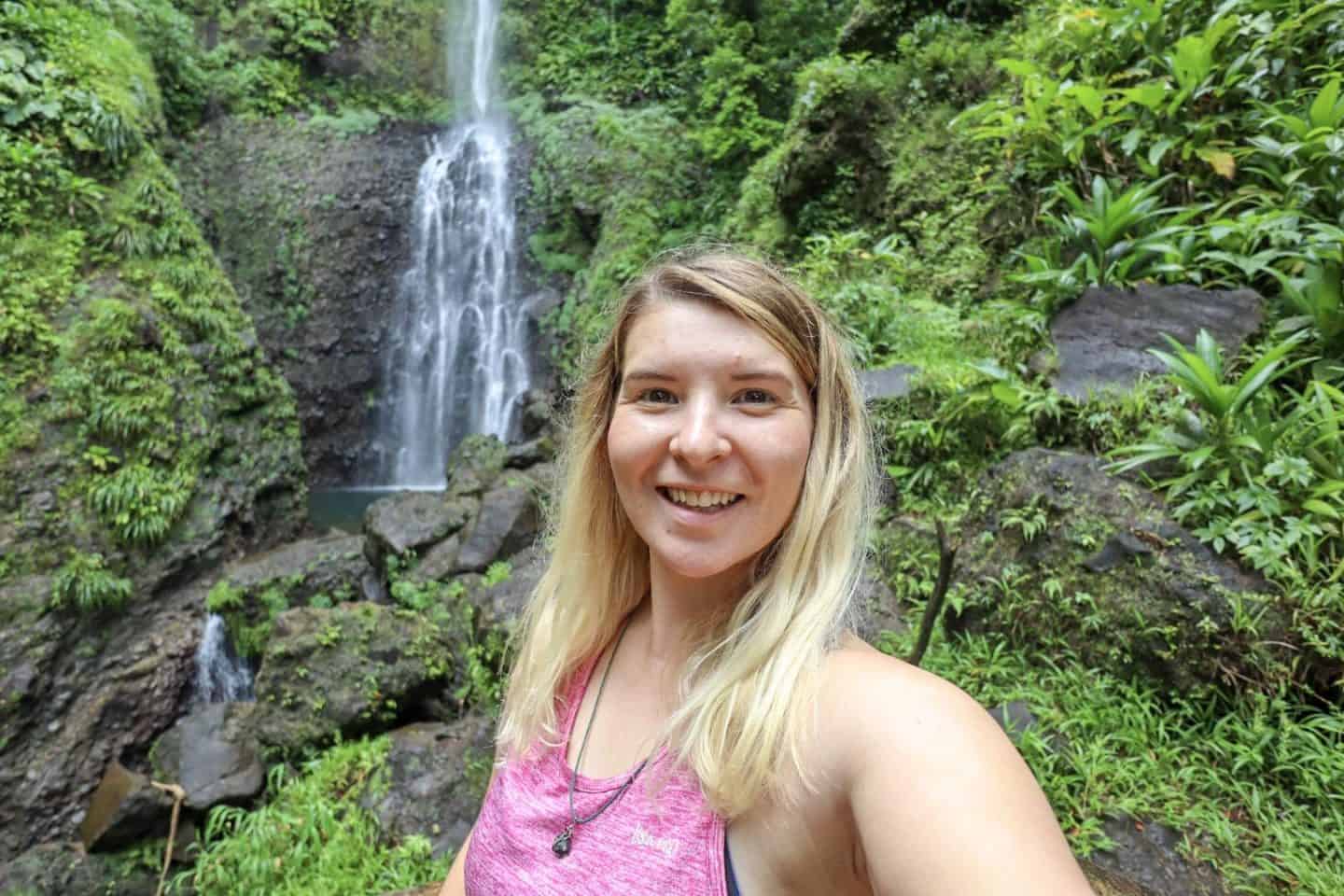 The Wandering Quinn Travel Blog Dominica travel guide, ellie quinn in hiking clothes by waterfall