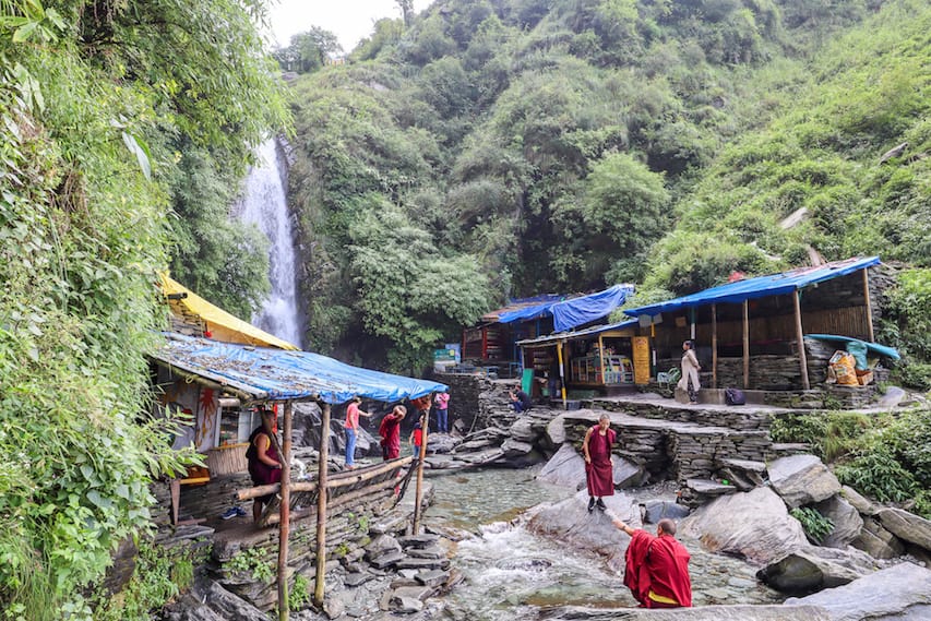 Bhagsu Waterfall base with monks by water | things to do in Bhagsu