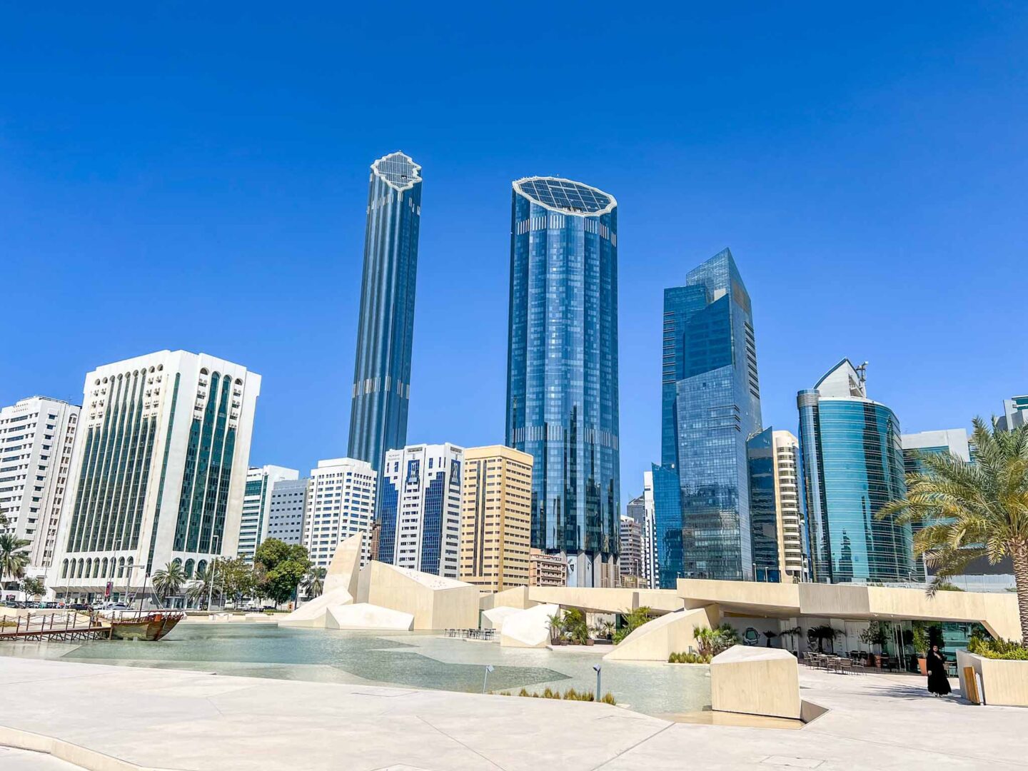 Things to do in Abu Dhabi, square with water, cafe and skyscrapers 
