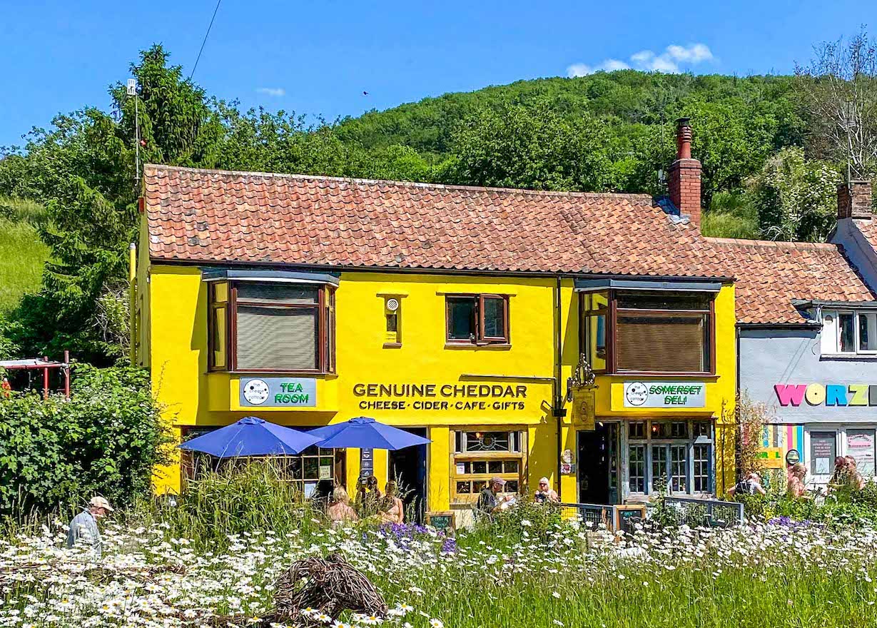 The Wandering Quinn Travel Blog Things to do in Cheddar Gorge, yellow building in Cheddar village