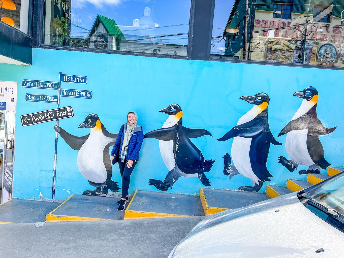 things to do in Ushuaia, Ellie with penguin art mural 