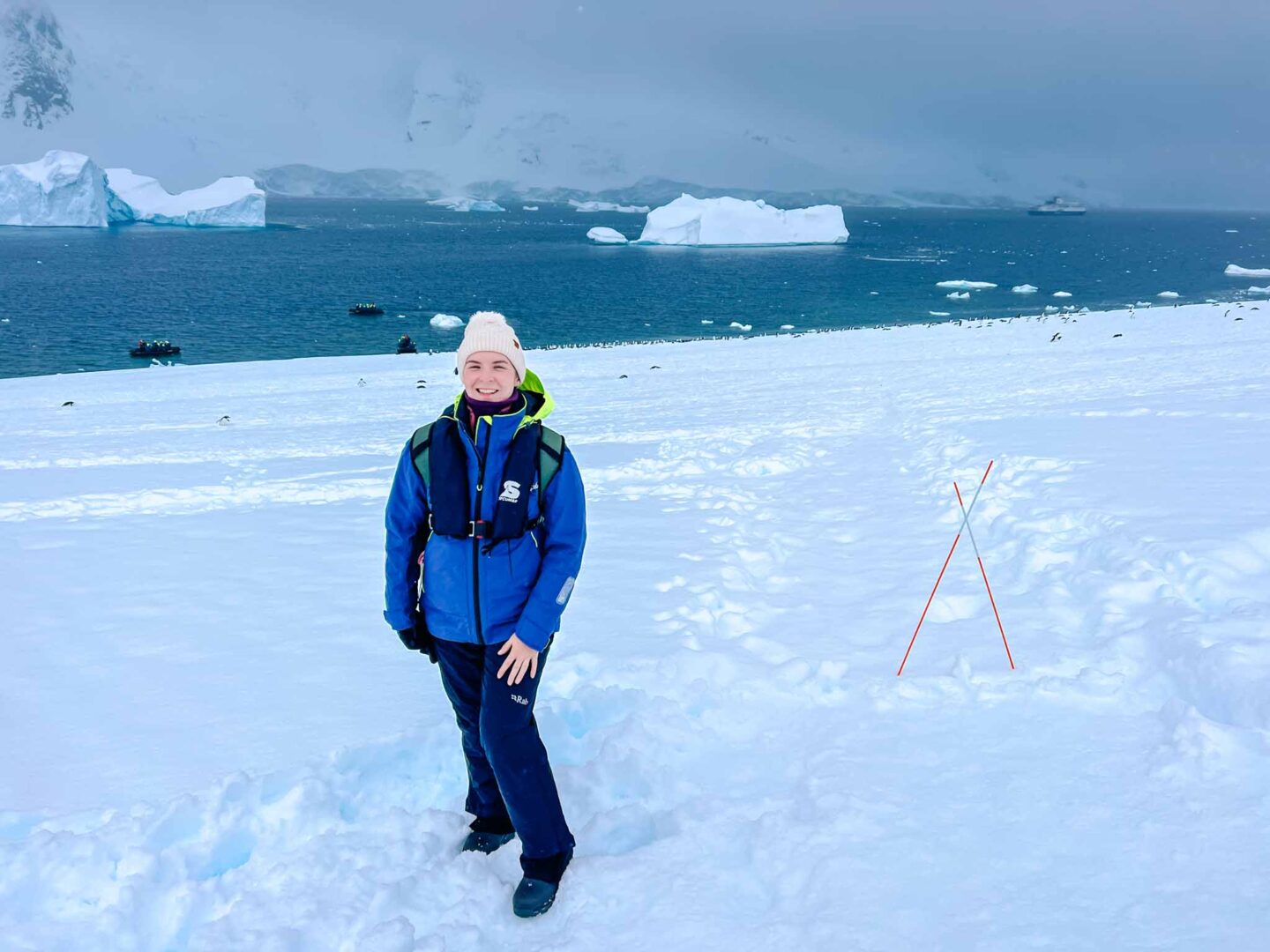 Antarctica in November, Best time to visit Antarctica, Ellie on fresh snow with penguins behind