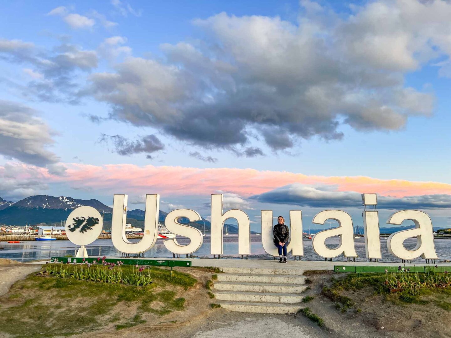 things to do in Ushuaia, Ellie at the Ushuaia sign at sunset