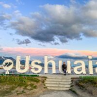 things to do in Ushuaia, Ellie at the Ushuaia sign at sunset