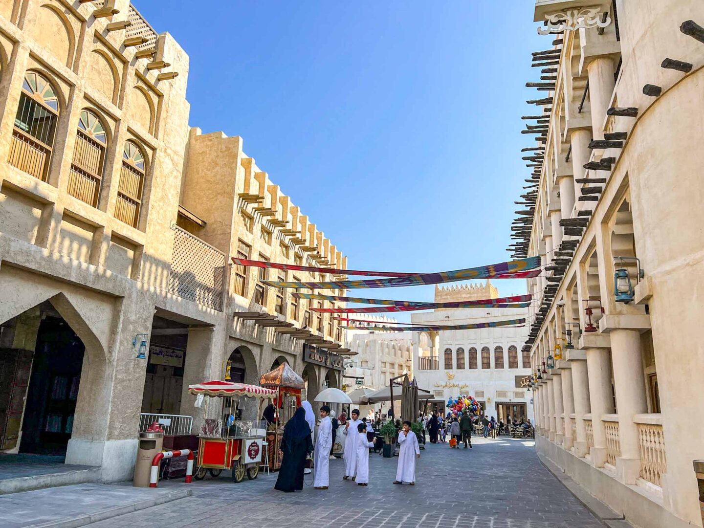 Family in traditional clothing in Souq Waqif, Qatar dress code, what to wear in Qatar,