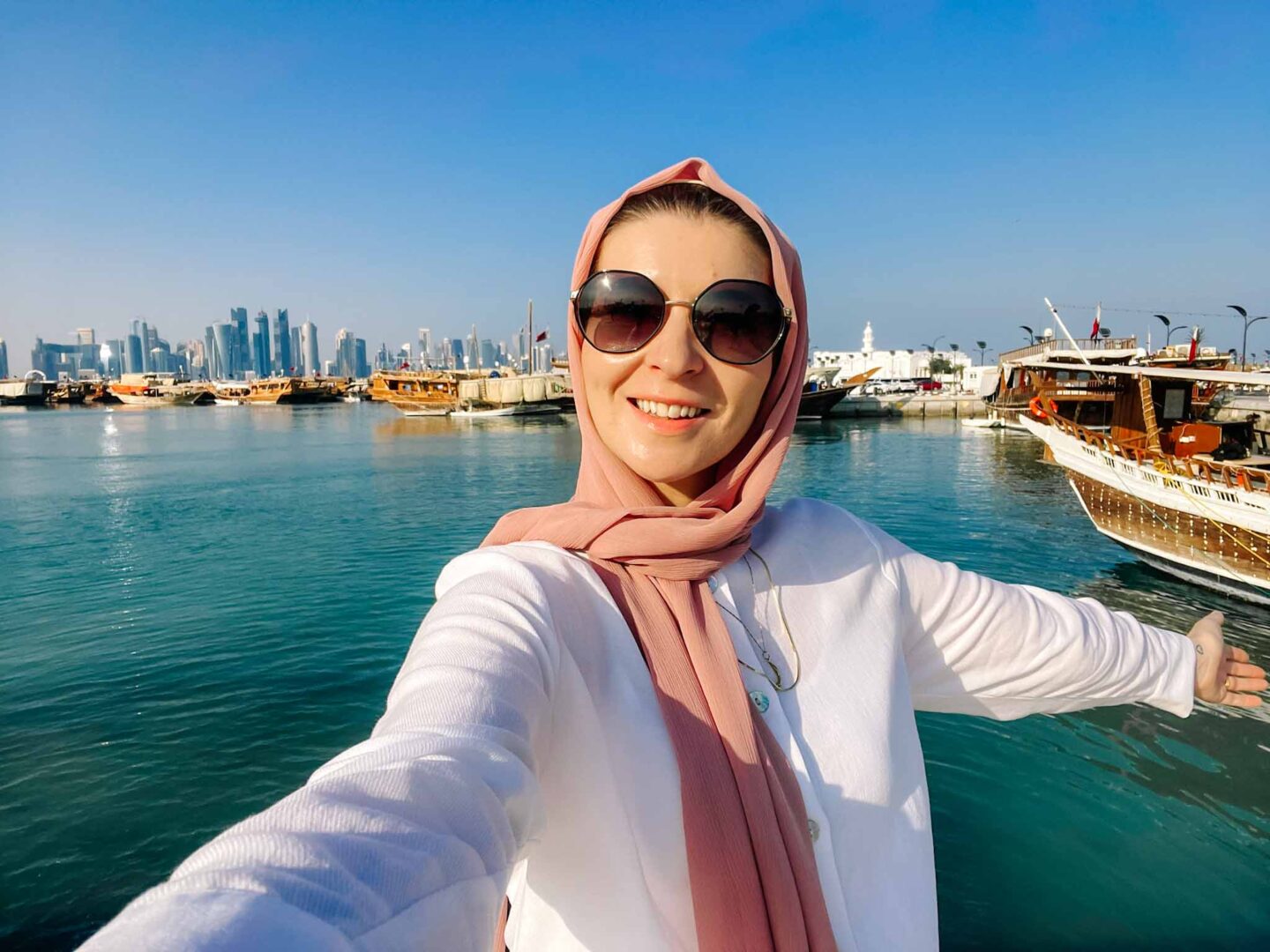 Ellie with Doha skyline behind her, Qatar dress code, what to wear in Qatar,