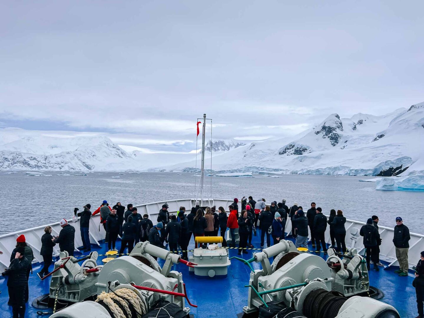 passengers on front of ship in Antarctica, Can you visit Antarctica, Why do people visit Antarctica, 