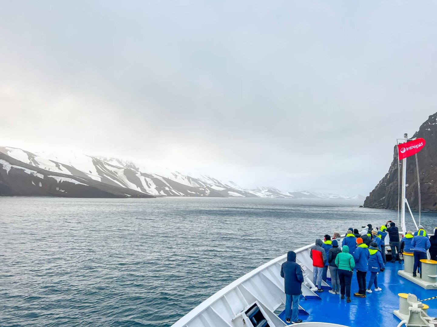 passengers on front of the ship in Antarctica, Can you visit Antarctica, Why do people visit Antarctica,