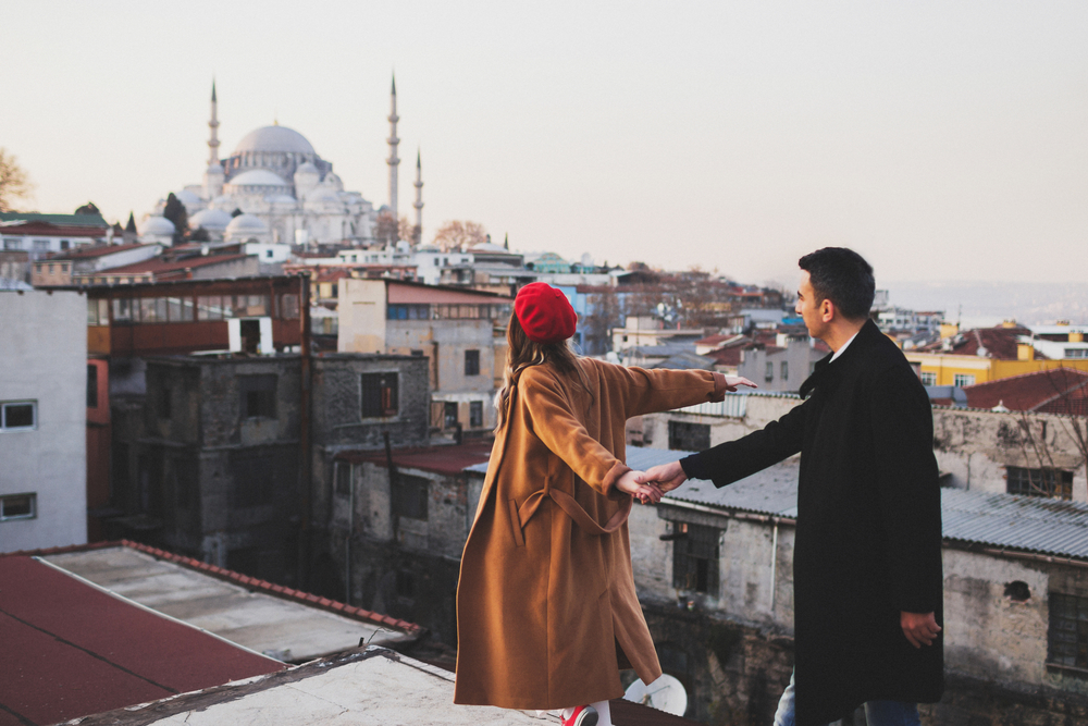 what to wear in Turkey, couple in coats in Istanbul by mosque