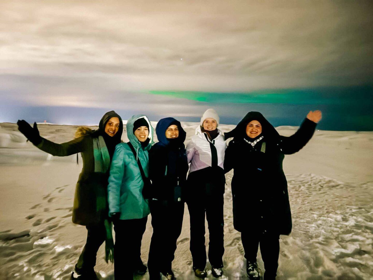 4 day iceland itinerary, group of 5 women with the Northern Lights behind them