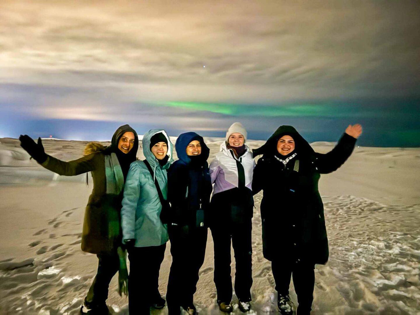 The Wandering Quinn Travel Blog what to wear in Iceland in winter, group with northern lights in iceland