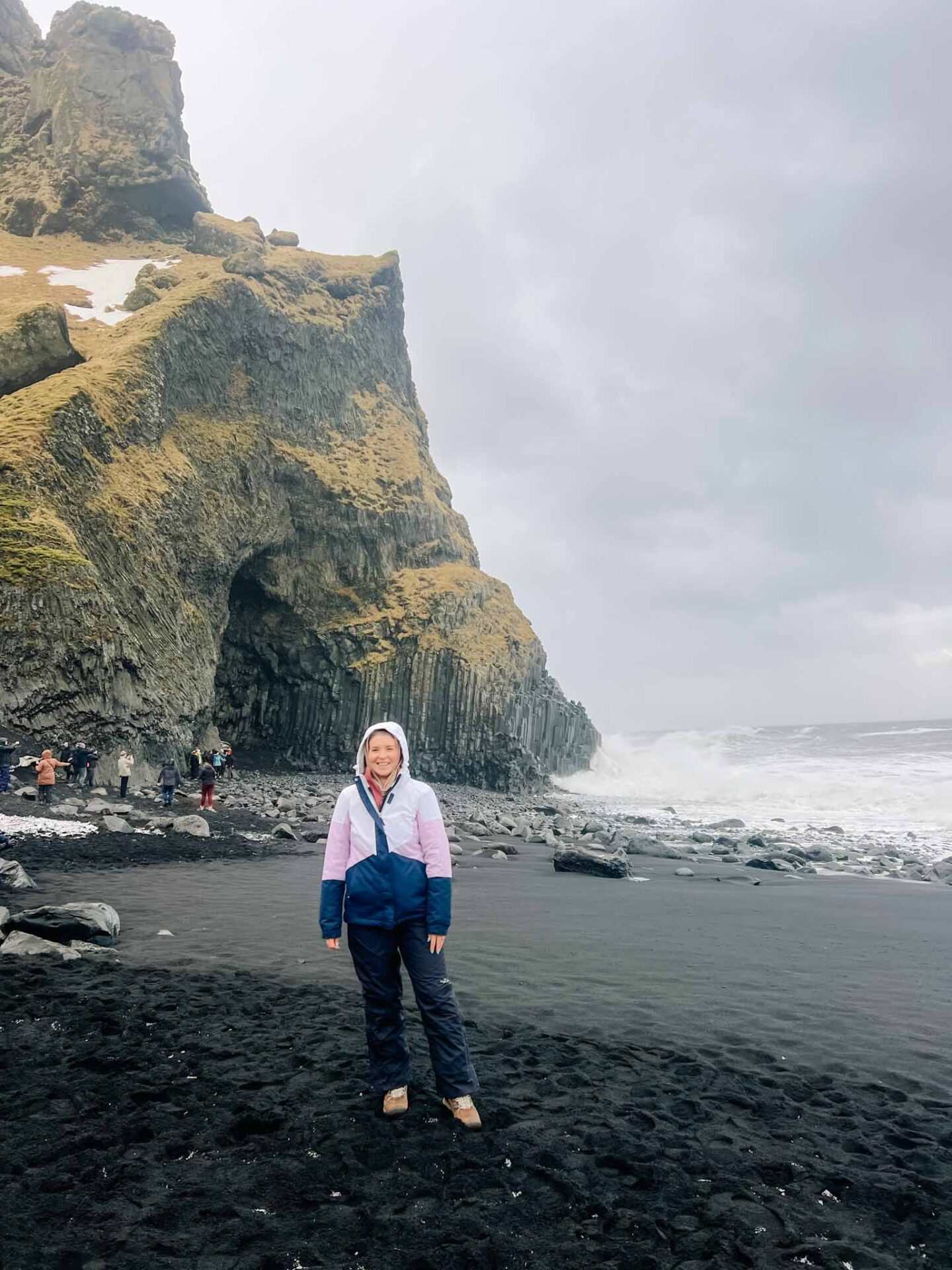 The Wandering Quinn Travel Blog what to wear in Iceland in winter, Ellie at black beach Iceland in winter clothes