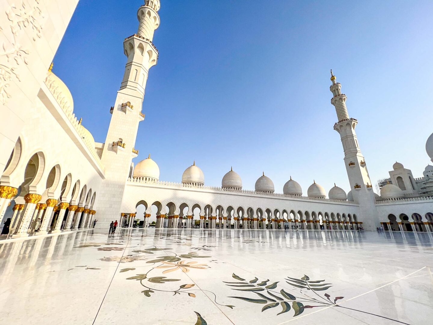 The Wandering Quinn Travel Blog Dubai vs Abu Dhabi, Sheikh Zayed Mosque in the afternoon with blue sky