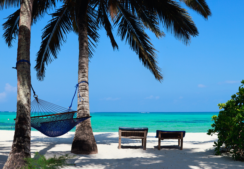 Best countries to visit in August, white sand, blue water beach in Zanzibar