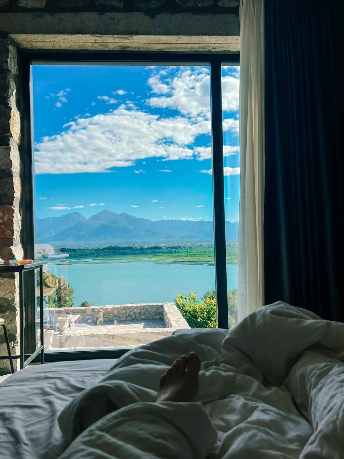 The Wandering Quinn Travel Blog one day in Theth Albania,  view of Lake Shkodar from bed at Rustico Hotel