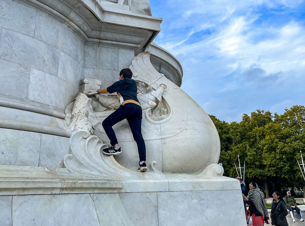 The Wandering Quinn Travel Blog kids climbing on statues